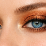 Close-up of blue eyes with bronze and gold eyeshadow tutorial, natural lighting